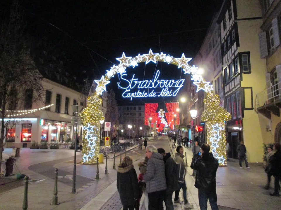 Brama świetlna z napisem „Strasbourg, Capitale de Noël” nad ulicą w centrum. Kiedy sprawdzaliśmy ten poradnik, miasto nie podało jeszcze oficjalnych dat jarmarków na 2026 rok.